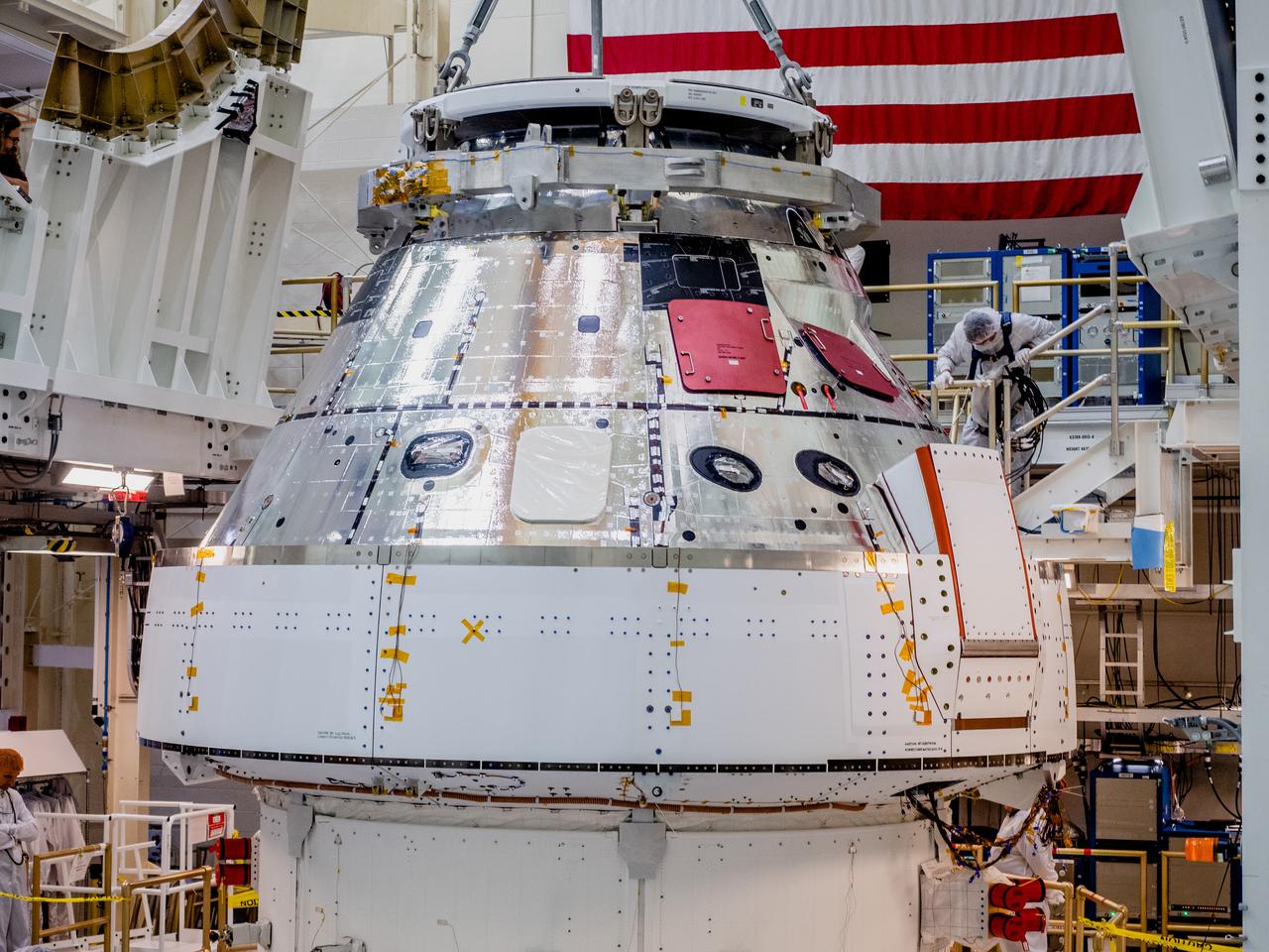 The Orion crew and service module stack for Artemis I was lifted out of the Final Assembly and Test (FAST) cell on November 11, 2019. The spacecraft has been stationed in the FAST cell since July for mating and closeout processing. The service module and crew module were moved separately into the cell, stacked and connected together for the mission. After lifting out of the cell, Orion will be attached to a tool called a verticator that rotates the stack from its vertical configuration to a horizontal configuration for transport to NASA’s Plum Brook Station in Sandusky, Ohio, where it will undergo full environmental testing to certify the complete vehicle for flight. Once the vehicle returns to Kennedy in several months, it will return to the FAST cell for installation of final panels left off for environmental testing purposes and the service module’s four solar arrays.