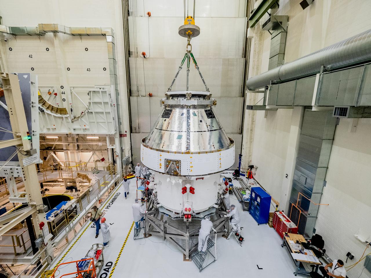 The Orion crew and service module stack for Artemis I was lifted out of the Final Assembly and Test (FAST) cell on November 11, 2019. The spacecraft has been stationed in the FAST cell since July for mating and closeout processing. The service module and crew module were moved separately into the cell, stacked and connected together for the mission. After lifting out of the cell, Orion will be attached to a tool called a verticator that rotates the stack from its vertical configuration to a horizontal configuration for transport to NASA’s Plum Brook Station in Sandusky, Ohio, where it will undergo full environmental testing to certify the complete vehicle for flight. Once the vehicle returns to Kennedy in several months, it will return to the FAST cell for installation of final panels left off for environmental testing purposes and the service module’s four solar arrays.