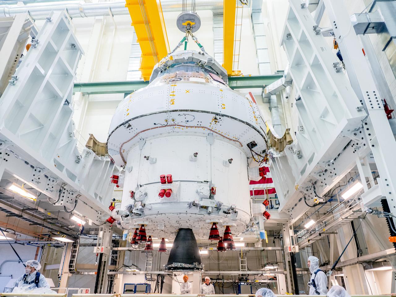 The Orion crew and service module stack for Artemis I was lifted out of the Final Assembly and Test (FAST) cell on November 11, 2019. The spacecraft has been stationed in the FAST cell since July for mating and closeout processing. The service module and crew module were moved separately into the cell, stacked and connected together for the mission. After lifting out of the cell, Orion will be attached to a tool called a verticator that rotates the stack from its vertical configuration to a horizontal configuration for transport to NASA’s Plum Brook Station in Sandusky, Ohio, where it will undergo full environmental testing to certify the complete vehicle for flight. Once the vehicle returns to Kennedy in several months, it will return to the FAST cell for installation of final panels left off for environmental testing purposes and the service module’s four solar arrays.