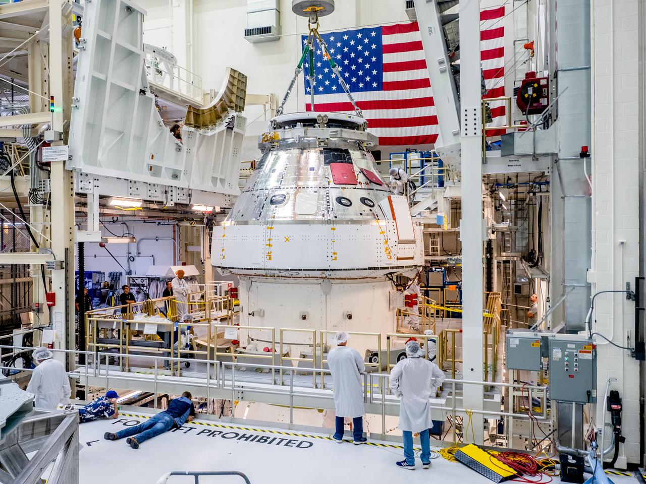 The Orion crew and service module stack for Artemis I was lifted out of the Final Assembly and Test (FAST) cell on November 11, 2019. The spacecraft has been stationed in the FAST cell since July for mating and closeout processing. The service module and crew module were moved separately into the cell, stacked and connected together for the mission. After lifting out of the cell, Orion will be attached to a tool called a verticator that rotates the stack from its vertical configuration to a horizontal configuration for transport to NASA’s Plum Brook Station in Sandusky, Ohio, where it will undergo full environmental testing to certify the complete vehicle for flight. Once the vehicle returns to Kennedy in several months, it will return to the FAST cell for installation of final panels left off for environmental testing purposes and the service module’s four solar arrays.