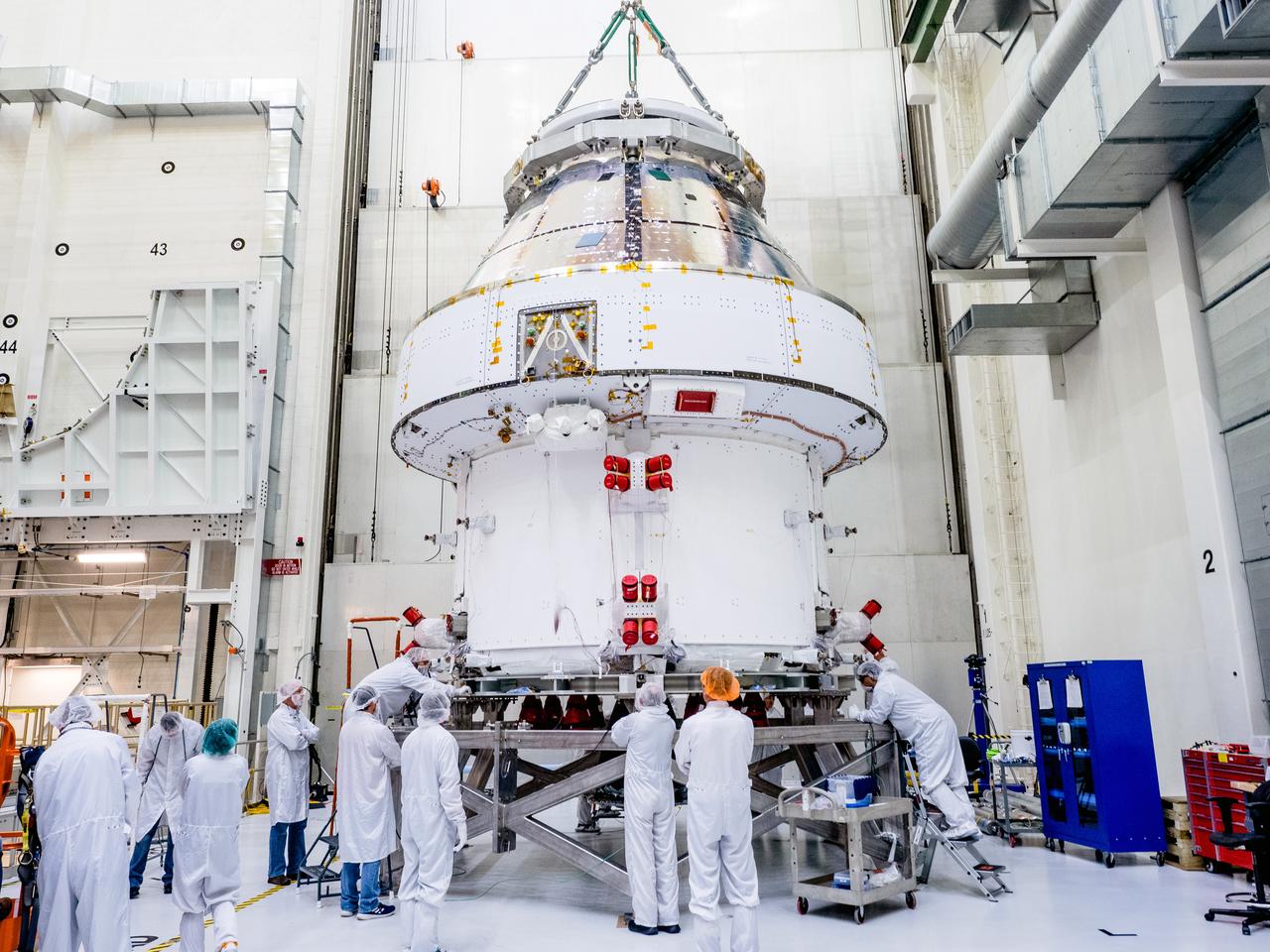 The Orion crew and service module stack for Artemis I was lifted out of the Final Assembly and Test (FAST) cell on November 11, 2019. The spacecraft has been stationed in the FAST cell since July for mating and closeout processing. The service module and crew module were moved separately into the cell, stacked and connected together for the mission. After lifting out of the cell, Orion will be attached to a tool called a verticator that rotates the stack from its vertical configuration to a horizontal configuration for transport to NASA’s Plum Brook Station in Sandusky, Ohio, where it will undergo full environmental testing to certify the complete vehicle for flight. Once the vehicle returns to Kennedy in several months, it will return to the FAST cell for installation of final panels left off for environmental testing purposes and the service module’s four solar arrays.