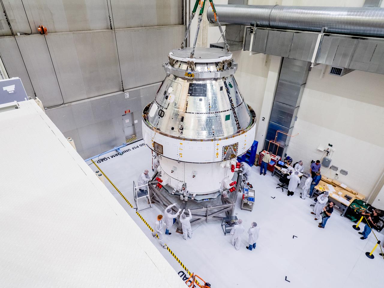 The Orion crew and service module stack for Artemis I was lifted out of the Final Assembly and Test (FAST) cell on November 11, 2019. The spacecraft has been stationed in the FAST cell since July for mating and closeout processing. The service module and crew module were moved separately into the cell, stacked and connected together for the mission. After lifting out of the cell, Orion will be attached to a tool called a verticator that rotates the stack from its vertical configuration to a horizontal configuration for transport to NASA’s Plum Brook Station in Sandusky, Ohio, where it will undergo full environmental testing to certify the complete vehicle for flight. Once the vehicle returns to Kennedy in several months, it will return to the FAST cell for installation of final panels left off for environmental testing purposes and the service module’s four solar arrays.
