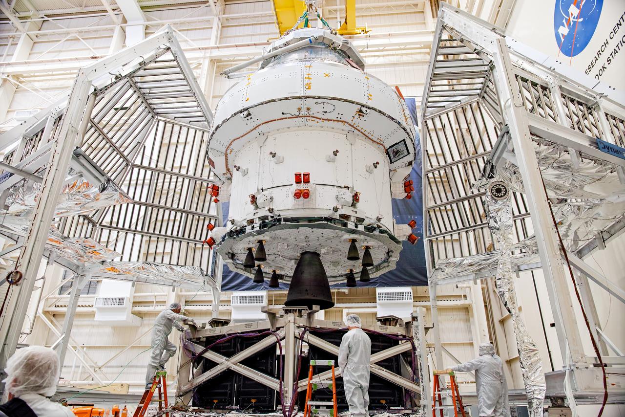 NASA’s Orion spacecraft–the crew module and European-built service module—is being lifted on Dec. 1, 2019 into a thermal cage and readied for its move into the vacuum chamber at NASA’s Neil A. Armstrong Test Facility in Ohio (formerly Plum Brook Station) for testing. Testing begins with a 60-day thermal test, where the spacecraft will be subjected to temperatures ranging from -250 to 300-degrees Fahrenheit to ensure it can withstand the harsh environment of space during Artemis missions. These extreme temperatures simulate flying in-and-out of sunlight and shadow in space using Heat Flux, a specially-designed system that heats specific parts of the spacecraft at any given time. Orion will also be surrounded on all sides by a set of large panels, called a cryogenic-shroud, that will provide the cold background temperatures of space.