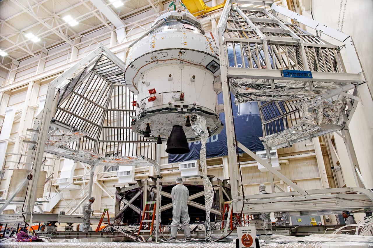 NASA’s Orion spacecraft–the crew module and European-built service module—is being lifted on Dec. 1, 2019 into a thermal cage and readied for its move into the vacuum chamber at NASA’s Neil A. Armstrong Test Facility in Ohio (formerly Plum Brook Station) for testing. Testing begins with a 60-day thermal test, where the spacecraft will be subjected to temperatures ranging from -250 to 300-degrees Fahrenheit to ensure it can withstand the harsh environment of space during Artemis missions. These extreme temperatures simulate flying in-and-out of sunlight and shadow in space using Heat Flux, a specially-designed system that heats specific parts of the spacecraft at any given time. Orion will also be surrounded on all sides by a set of large panels, called a cryogenic-shroud, that will provide the cold background temperatures of space.