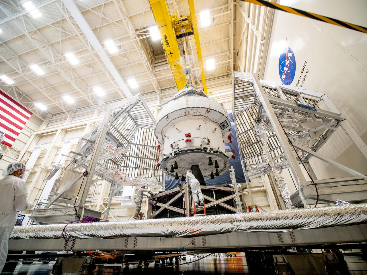 NASA’s Orion spacecraft–the crew module and European-built service module—is being lifted on Dec. 1, 2019 into a thermal cage and readied for its move into the vacuum chamber at NASA’s Neil A. Armstrong Test Facility in Ohio (formerly Plum Brook Station) for testing. Testing begins with a 60-day thermal test, where the spacecraft will be subjected to temperatures ranging from -250 to 300-degrees Fahrenheit to ensure it can withstand the harsh environment of space during Artemis missions. These extreme temperatures simulate flying in-and-out of sunlight and shadow in space using Heat Flux, a specially-designed system that heats specific parts of the spacecraft at any given time. Orion will also be surrounded on all sides by a set of large panels, called a cryogenic-shroud, that will provide the cold background temperatures of space.