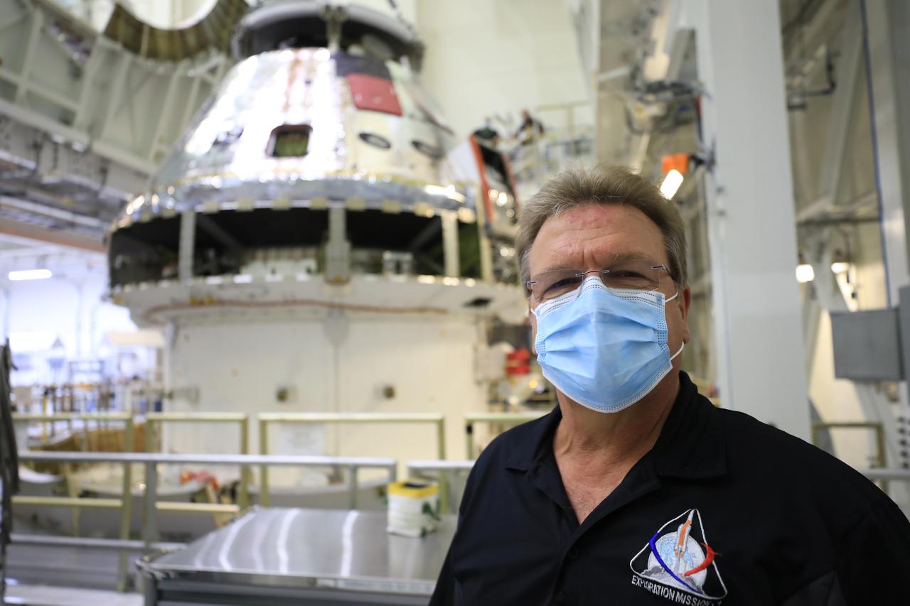 Jules Schneider, Lockheed Martin Assembly, Test and Launch Operations director, is shown inside the Neil Armstrong Operations and Checkout Building high bay in front of the FAST cell as the Artemis I Orion spacecraft is lowered by crane after installation of the spacecraft adapter (SA) cone was completed on Aug. 20, 2020. This is one of the final major hardware operations the spacecraft will undergo during closeout processing prior to being integrated with the Space Launch System (SLS) rocket in preparation for the first Artemis mission. The spacecraft adapter cone connects the bottom portion of Orion’s service module to the top part of the rocket known as the interim cryogenic propulsion stage (ICPS). Orion will fly on the agency’s Artemis I mission – the first in a series of increasingly complex missions to the Moon that will ultimately lead to the exploration of Mars.