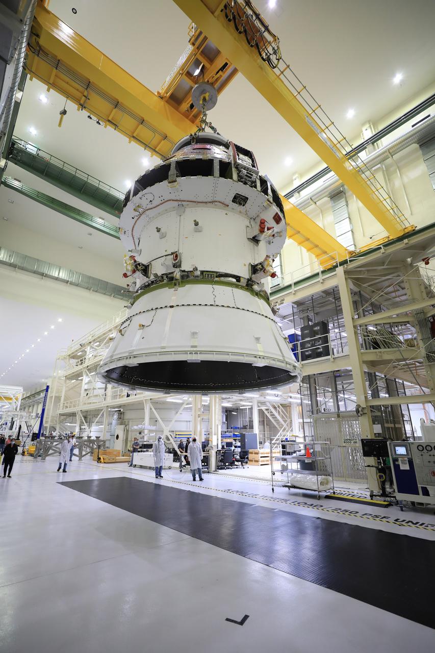The Artemis I Orion spacecraft with its spacecraft adapter cone attached, is moved by crane along the high bay inside the Neil Armstrong Operations and Checkout Building at NASA’s Kennedy Space Center in Florida on Aug. 20, 2020. This is one of the final major hardware operations the spacecraft will undergo during closeout processing prior to being integrated with the Space Launch System (SLS) rocket in preparation for the first Artemis mission. The spacecraft adapter cone connects the bottom portion of Orion’s service module to the top part of the rocket known as the interim cryogenic propulsion stage (ICPS). Orion will fly on the agency’s Artemis I mission – the first in a series of increasingly complex missions to the Moon that will ultimately lead to the exploration of Mars.