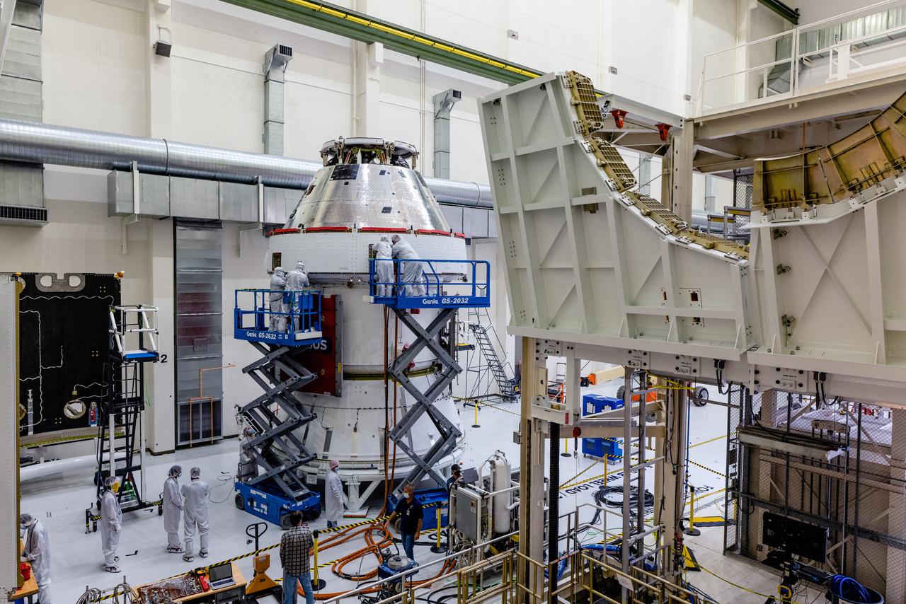 In the Operations and Checkout Building (O&amp;C) at Kennedy Space Center, three spacecraft adapter jettison (SAJ) fairings are prepared for installation and will be moved into place by technicians with Lockheed Martin, lead contractor for Orion on Oct. 12, 2020. They will be secured around the spacecraft, encapsulating the European Service Module to protect it from the harsh environment as the spacecraft is propelled out of Earth’s atmosphere atop the Space Launch System (SLS) rocket during NASA’s Artemis I mission. The next time the solar array wings will be visible will be when Orion is in space. Artemis I will test the Orion spacecraft and SLS as an integrated system ahead of crewed flights to the Moon.