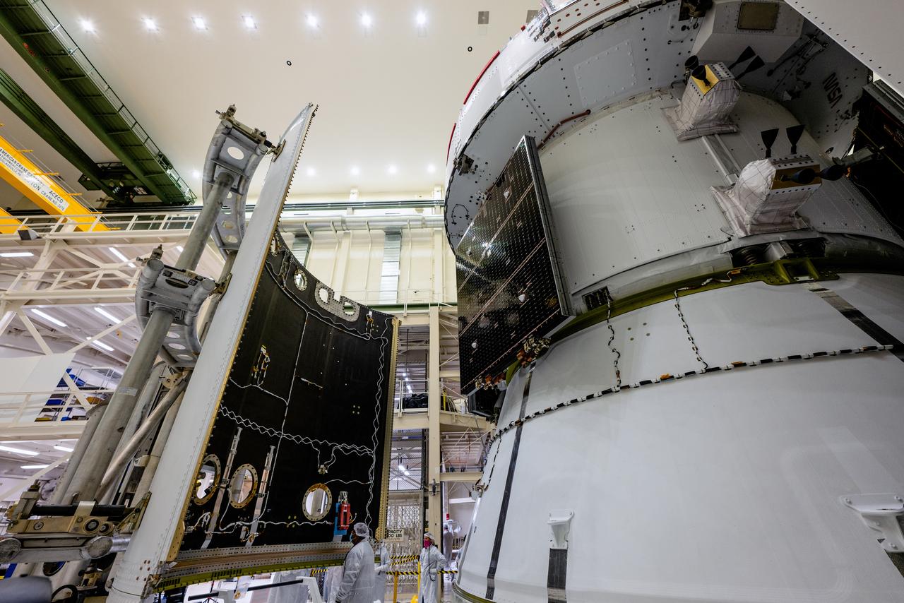 In the Operations and Checkout Building (O&amp;C) at Kennedy Space Center, three spacecraft adapter jettison (SAJ) fairings are prepared for installation and will be moved into place by technicians with Lockheed Martin, lead contractor for Orion on Oct. 12, 2020. They will be secured around the spacecraft, encapsulating the European Service Module to protect it from the harsh environment as the spacecraft is propelled out of Earth’s atmosphere atop the Space Launch System (SLS) rocket during NASA’s Artemis I mission. The next time the solar array wings will be visible will be when Orion is in space. Artemis I will test the Orion spacecraft and SLS as an integrated system ahead of crewed flights to the Moon.