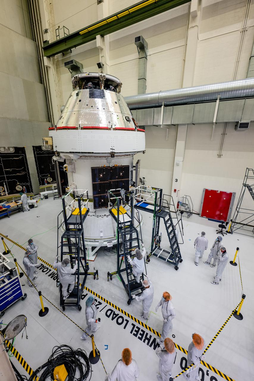 In the Operations and Checkout Building (O&amp;C) at Kennedy Space Center, three spacecraft adapter jettison (SAJ) fairings are prepared for installation and will be moved into place by technicians with Lockheed Martin, lead contractor for Orion on Oct. 12, 2020. They will be secured around the spacecraft, encapsulating the European Service Module to protect it from the harsh environment as the spacecraft is propelled out of Earth’s atmosphere atop the Space Launch System (SLS) rocket during NASA’s Artemis I mission. The next time the solar array wings will be visible will be when Orion is in space. Artemis I will test the Orion spacecraft and SLS as an integrated system ahead of crewed flights to the Moon.