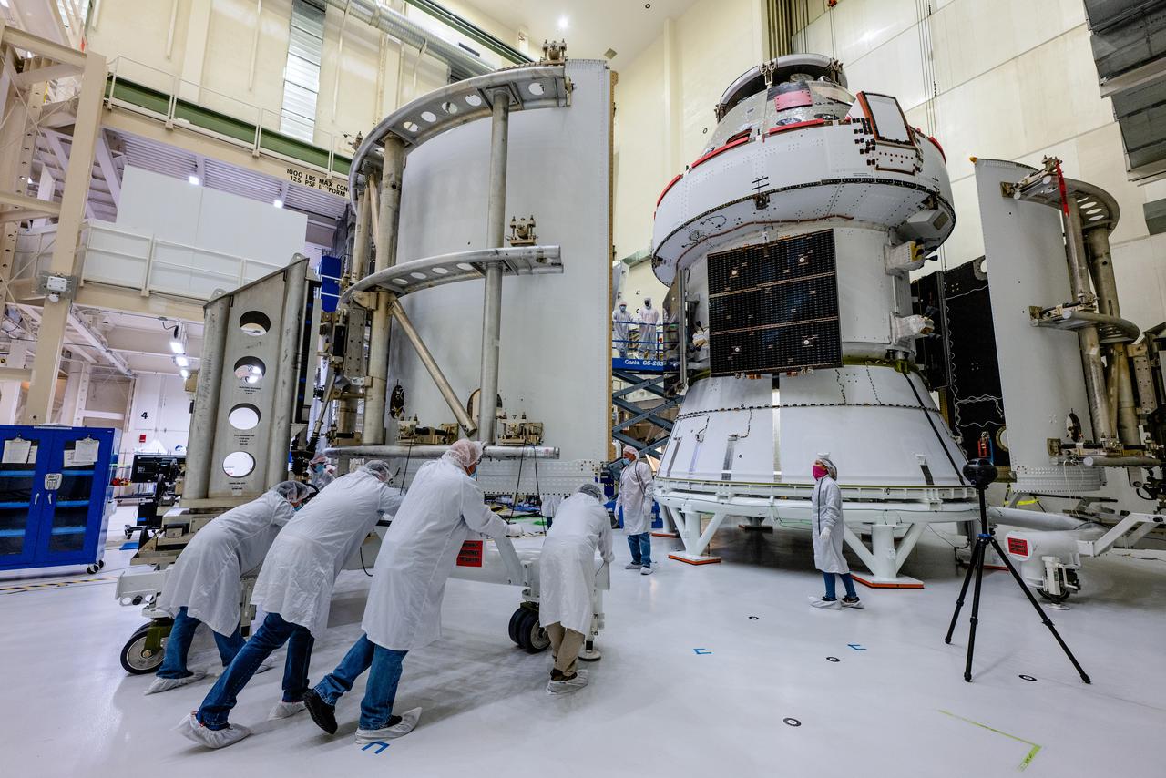 In the Operations and Checkout Building (O&amp;C) at Kennedy Space Center, three spacecraft adapter jettison (SAJ) fairings are prepared for installation and will be moved into place by technicians with Lockheed Martin, lead contractor for Orion on Oct. 12, 2020. They will be secured around the spacecraft, encapsulating the European Service Module to protect it from the harsh environment as the spacecraft is propelled out of Earth’s atmosphere atop the Space Launch System (SLS) rocket during NASA’s Artemis I mission. The next time the solar array wings will be visible will be when Orion is in space. Artemis I will test the Orion spacecraft and SLS as an integrated system ahead of crewed flights to the Moon.