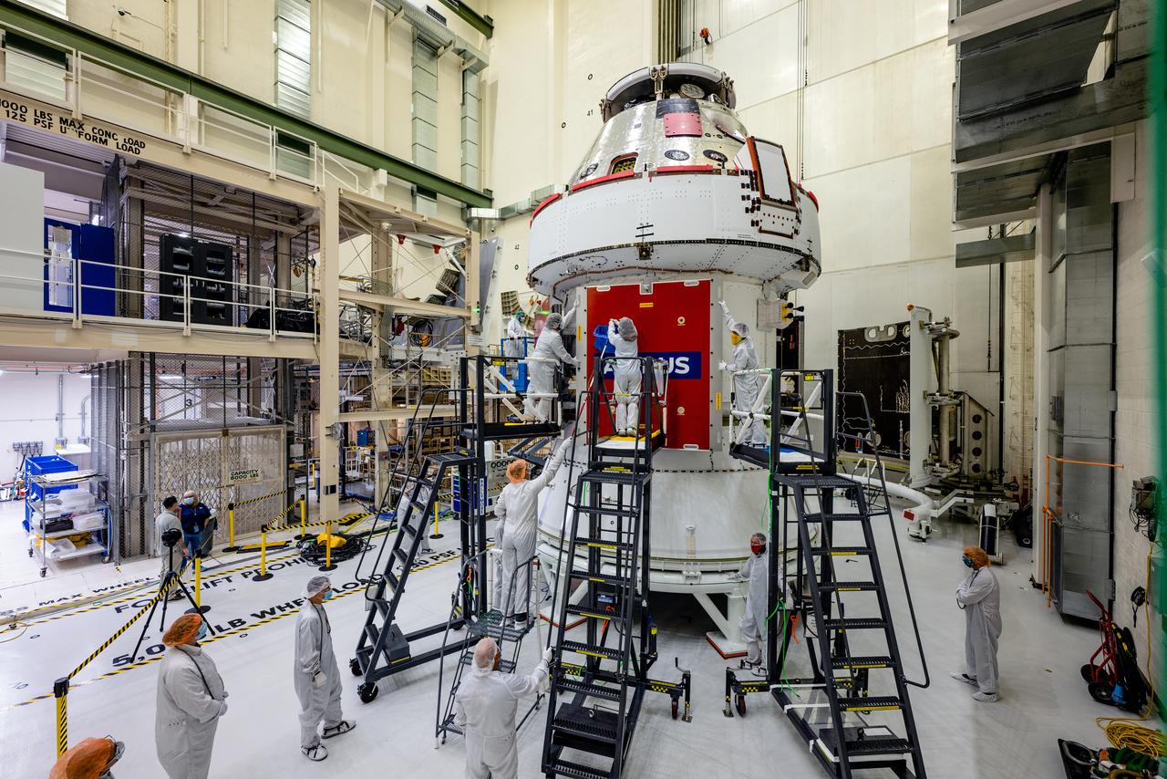 In the Operations and Checkout Building (O&amp;C) at Kennedy Space Center, three spacecraft adapter jettison (SAJ) fairings are prepared for installation and will be moved into place by technicians with Lockheed Martin, lead contractor for Orion on Oct. 12, 2020. They will be secured around the spacecraft, encapsulating the European Service Module to protect it from the harsh environment as the spacecraft is propelled out of Earth’s atmosphere atop the Space Launch System (SLS) rocket during NASA’s Artemis I mission. The next time the solar array wings will be visible will be when Orion is in space. Artemis I will test the Orion spacecraft and SLS as an integrated system ahead of crewed flights to the Moon.