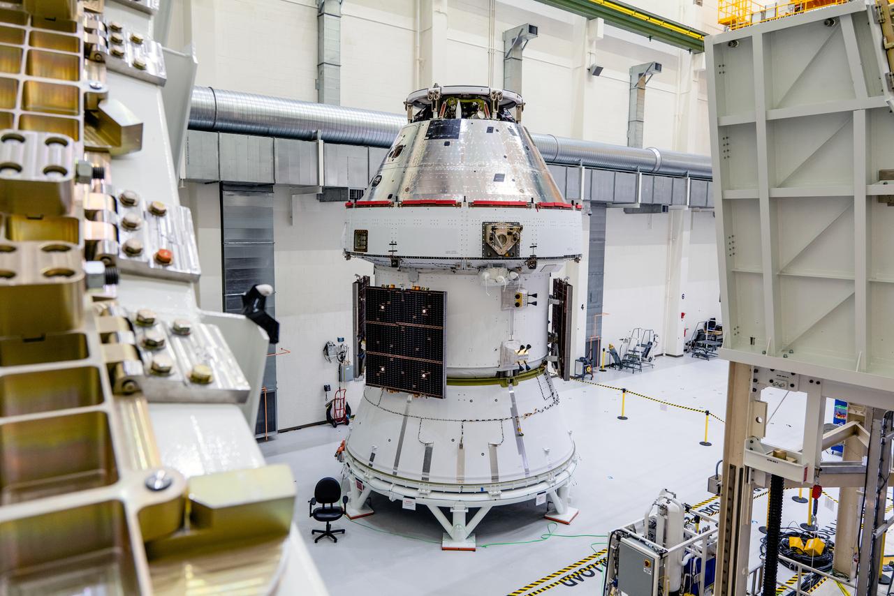 In the Operations and Checkout Building (O&amp;C) at Kennedy Space Center, three spacecraft adapter jettison (SAJ) fairings are prepared for installation and will be moved into place by technicians with Lockheed Martin, lead contractor for Orion on Oct. 12, 2020. They will be secured around the spacecraft, encapsulating the European Service Module to protect it from the harsh environment as the spacecraft is propelled out of Earth’s atmosphere atop the Space Launch System (SLS) rocket during NASA’s Artemis I mission. The next time the solar array wings will be visible will be when Orion is in space. Artemis I will test the Orion spacecraft and SLS as an integrated system ahead of crewed flights to the Moon.