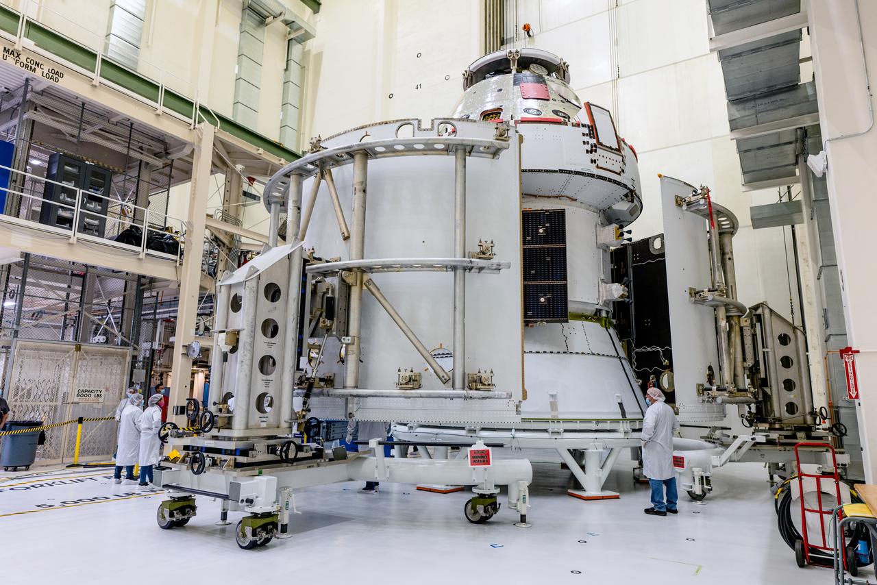 In the Operations and Checkout Building (O&amp;C) at Kennedy Space Center, three spacecraft adapter jettison (SAJ) fairings are prepared for installation and will be moved into place by technicians with Lockheed Martin, lead contractor for Orion on Oct. 12, 2020. They will be secured around the spacecraft, encapsulating the European Service Module to protect it from the harsh environment as the spacecraft is propelled out of Earth’s atmosphere atop the Space Launch System (SLS) rocket during NASA’s Artemis I mission. The next time the solar array wings will be visible will be when Orion is in space. Artemis I will test the Orion spacecraft and SLS as an integrated system ahead of crewed flights to the Moon.