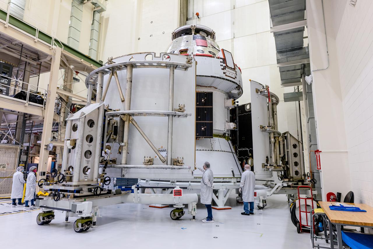 In the Operations and Checkout Building (O&amp;C) at Kennedy Space Center, three spacecraft adapter jettison (SAJ) fairings are prepared for installation and will be moved into place by technicians with Lockheed Martin, lead contractor for Orion on Oct. 12, 2020. They will be secured around the spacecraft, encapsulating the European Service Module to protect it from the harsh environment as the spacecraft is propelled out of Earth’s atmosphere atop the Space Launch System (SLS) rocket during NASA’s Artemis I mission. The next time the solar array wings will be visible will be when Orion is in space. Artemis I will test the Orion spacecraft and SLS as an integrated system ahead of crewed flights to the Moon.