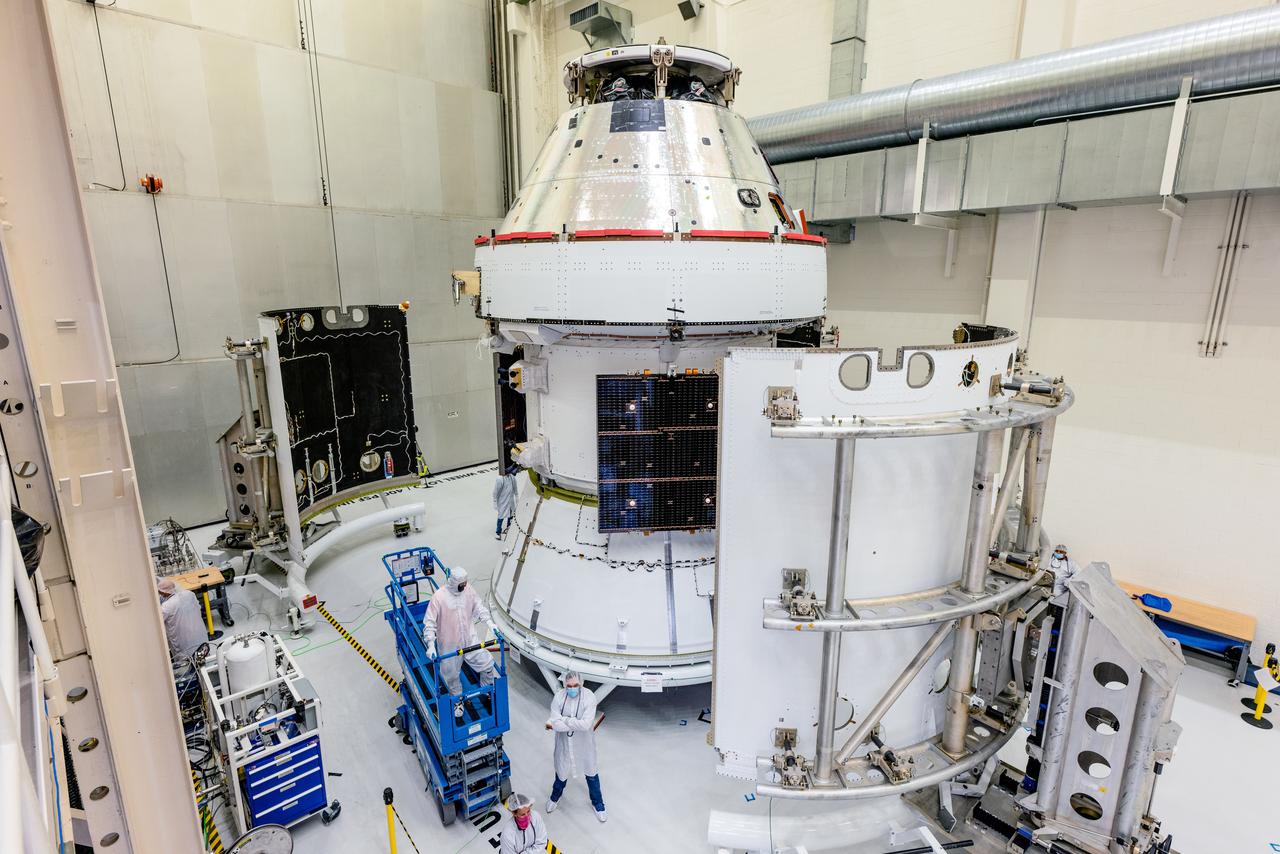 In the Operations and Checkout Building (O&amp;C) at Kennedy Space Center, three spacecraft adapter jettison (SAJ) fairings are prepared for installation and will be moved into place by technicians with Lockheed Martin, lead contractor for Orion on Oct. 12, 2020. They will be secured around the spacecraft, encapsulating the European Service Module to protect it from the harsh environment as the spacecraft is propelled out of Earth’s atmosphere atop the Space Launch System (SLS) rocket during NASA’s Artemis I mission. The next time the solar array wings will be visible will be when Orion is in space. Artemis I will test the Orion spacecraft and SLS as an integrated system ahead of crewed flights to the Moon.