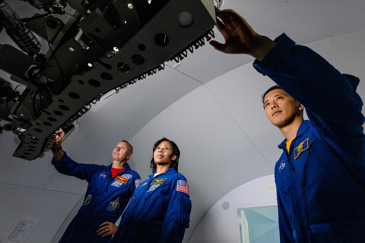 NASA Astronauts Stephanie Wilson, Jonny Kim, and Randy Bresnik take a look at the Orion spacecraft simulator that recently arrived at the agency’s Johnson Space Center in Houston on Dec. 8, 2020. The simulator provides the ability for astronauts, engineers, and flight controllers to train and practice for scenarios during Artemis missions to the Moon. The interior of the simulator is being outfitted with Orion’s display and control system and crew seats to mimic what astronaut will experience during liftoff to the lunar vicinity and on their way back home to Earth...Kim and Wilson are among the 18 astronauts recently named to the Artemis Team of astronauts eligible to be selected for Artemis missions to the Moon. Bresnik is currently the assistant to the chief of the astronaut office for exploration. NASA is targeting 2023 for Artemis II, the first mission with crew, with the Orion Spacecraft set to launch atop the agency’s Space Launch System rocket. The mission will send astronauts around the Moon and return them back to Earth, a flight that will set the stage for the first woman and next man to step foot on the Moon.