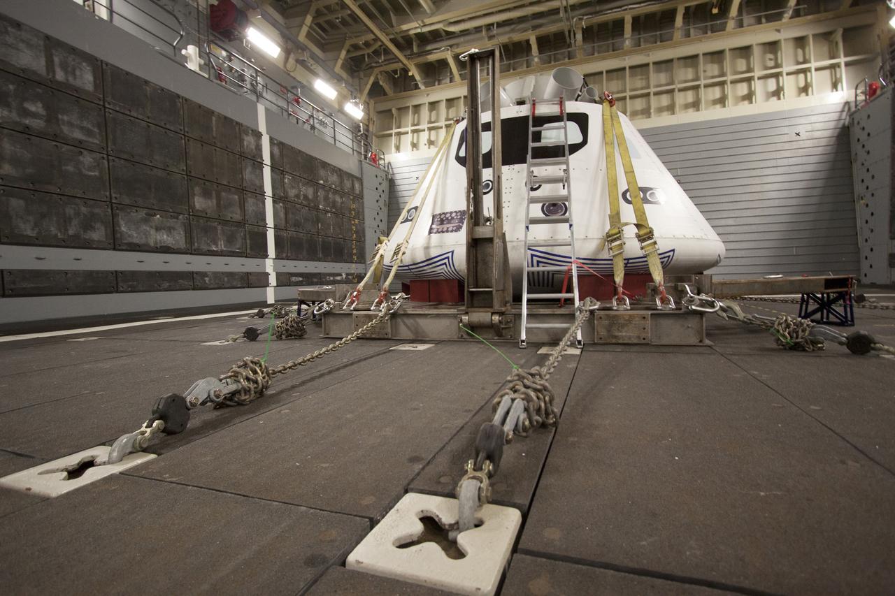 The Orion boilerplate test vehicle is secured in the well deck of the USS San Diego at the U.S. Naval Base San Diego in California on Feb. 18, 2014. Orion was transported about 100 miles offshore for an underway recovery test. NASA and the U.S. Navy conducted tests to prepare for recovery of the Orion crew module, forward bay cover and parachutes on its return from a deep space mission. The underway recovery test will allow the teams to demonstrate and evaluate the recovery processes, procedures, hardware and personnel in open waters. During the testing, the tether lines were unable to support the tension caused by crew module motion that was driven by wave turbulence in the well deck of the ship. NASA and the U.S. Navy are reviewing the testing data collected to evaluate the next steps. The Ground Systems Development and Operations Program conducted the underway recovery tests. Orion is the exploration spacecraft designed to carry astronauts to destinations not yet explored by humans, including an asteroid and Mars. It will have emergency abort capability, sustain the crew during space travel and provide safe re-entry from deep space return velocities.