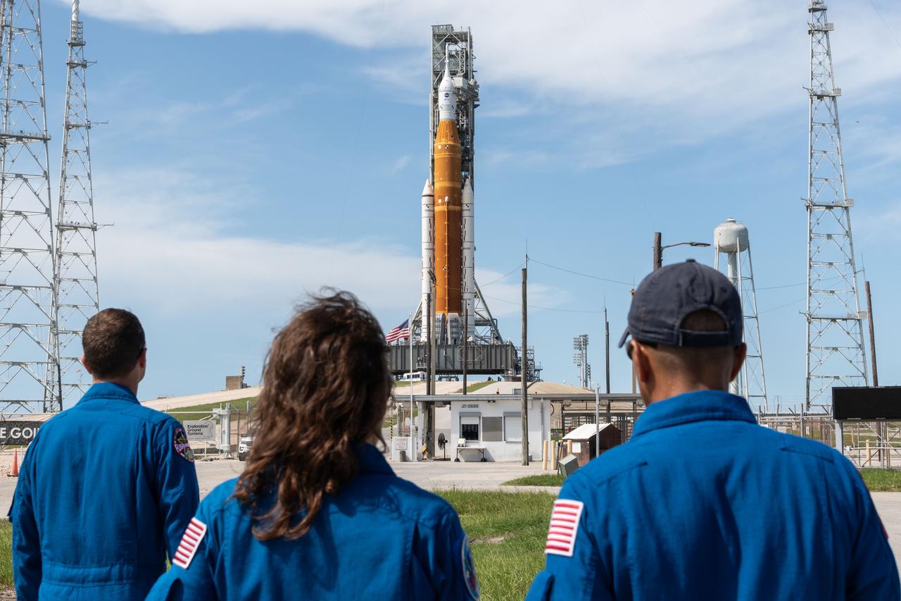 From left to right, NASA Astronauts Reid Wiseman, Christina Koch, and Joe Acaba view the Space Launch System and Orion spacecraft on Launch Pad 39B. They arrived via T-38 jet to support various pre-launch activities. Credit: NASA/Josh Valcarcel.