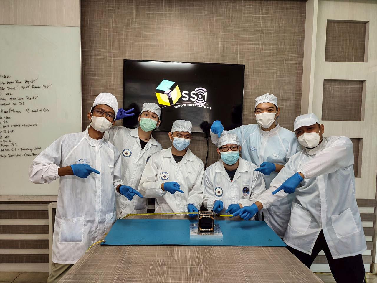jsc2022e068260 (11/1/2021) --- The Surya Satellite-1 and its Developer Team After Deployment Testing, shown left to right: Zulfa, Hery, Setra, Roberto, Suhan, Afiq.  The Surya Satellite-1 (SS-1) is the first Indonesian nanosatellite developed by university students at Surya University. SS-1 tests a satellite telecommunication system to serve amateur radio stations, and serves as a proof of concept of sensoric information transfer in rural areas for disaster mitigation application. Image Courtesy of The SS-1 Team.