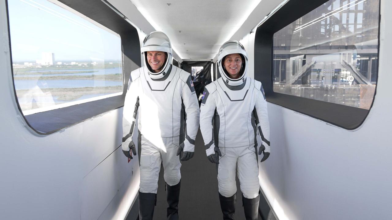 jsc2022e076175 (Oct. 5, 2022) --- (From left) SpaceX Crew-5 Pilot Josh Cassada and Commander Nicole Mann, both NASA astronauts, are pictured walking on the crew access arm toward the Dragon Endurance crew ship atop the Falcon 9 rocket at Kennedy Space Center's Launch Pad 39A in Florida.