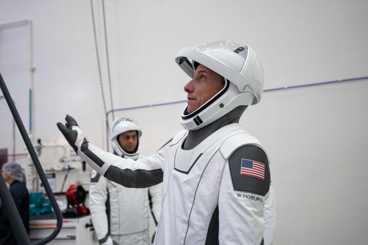 jsc2023e005756 (Jan. 30, 2023) --- Astronaut Warren "Woody" Hoburg of NASA's Commercial Crew Program, SpaceX Crew-6 Pilot, is pictured in his pressure suit during a crew equipment integration test at SpaceX headquarters in Hawthorne, California.  In the background, is cosmonaut Andrey Fedyaev of Roscosmos, SpaceX Crew-6 Mission Specialist. Credit: SpaceX