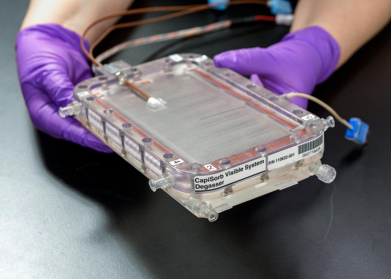 jsc2023e010167 (1/30/2023) --- CapiSorb Visible System flight unit degasser assembly in N240 room 133B. The CapiSorb Visible System will be launched on SpaceX CRS-27 in March 2023 to the International Space Station to demonstrate a liquid sorbent-based system that leverages the advantages of liquid control through capillary action to remove carbon dioxide from crewed atmospheres...Capillary wedges in the CapiSorb Visible System Degasser, shown here pre-flight, control and passively transport viscous liquid in microgravity in order to demonstrate capabilities needed for future liquid sorbent carbon dioxide removal technologies. The CapiSorb Visible System investigation demonstrates a liquid control using capillary forces, over a range of liquid properties that are characteristic of liquid carbon dioxide sorbents. Image courtesy of NASA's Ames Research Center.