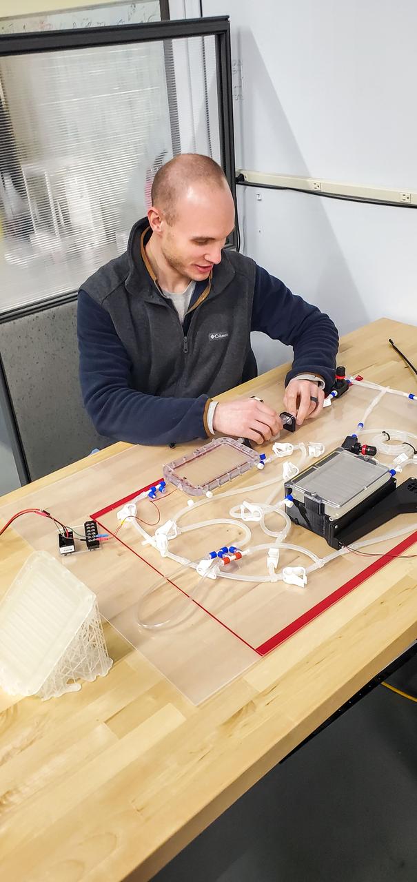 jsc2023e010172 (2/1/2023) --- Logan Torres, Design Engineer for the CapiSorb Visible System, configures the system pre-flight for performance testing. The capillary wedges in the degasser, contactor and capillary condensing heat exchanger control and passively transport viscous liquid in microgravity in order to demonstrate capabilities needed for future liquid sorbent carbon dioxide removal technologies. The CapiSorb Visible System investigation demonstrates a liquid control using capillary forces, over a range of properties that are characteristic of liquids which absorb carbon dioxide. Image courtesy of IRPI, LLC.