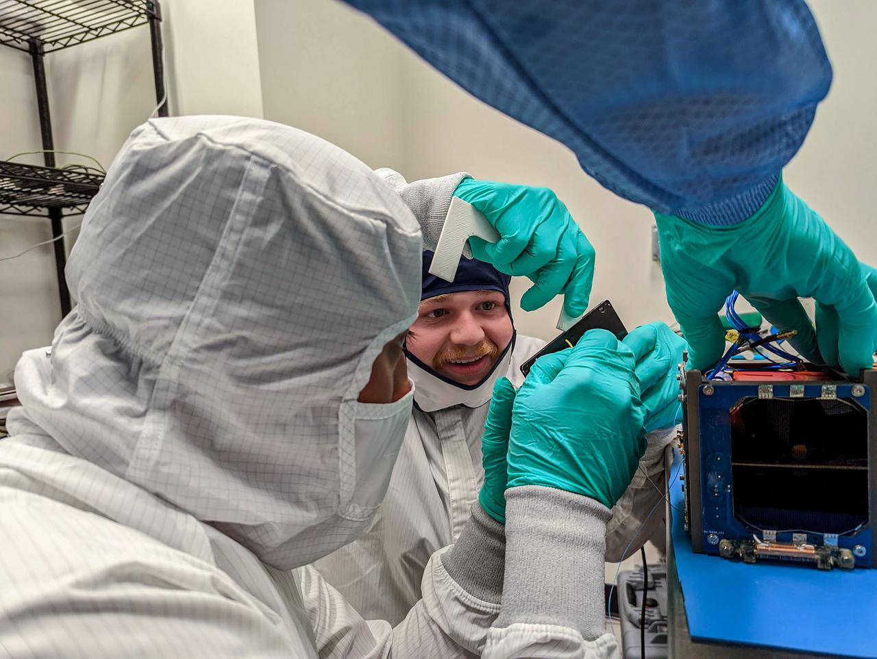 jsc2023e010185 (12/13/2022) --- Pair of students install a solar array panel during the flight assembly of LightCube. From left to right: David Ordaz Perez and Chandler Hutchens. Image courtesy of Jaime Sanchez de la Vega.