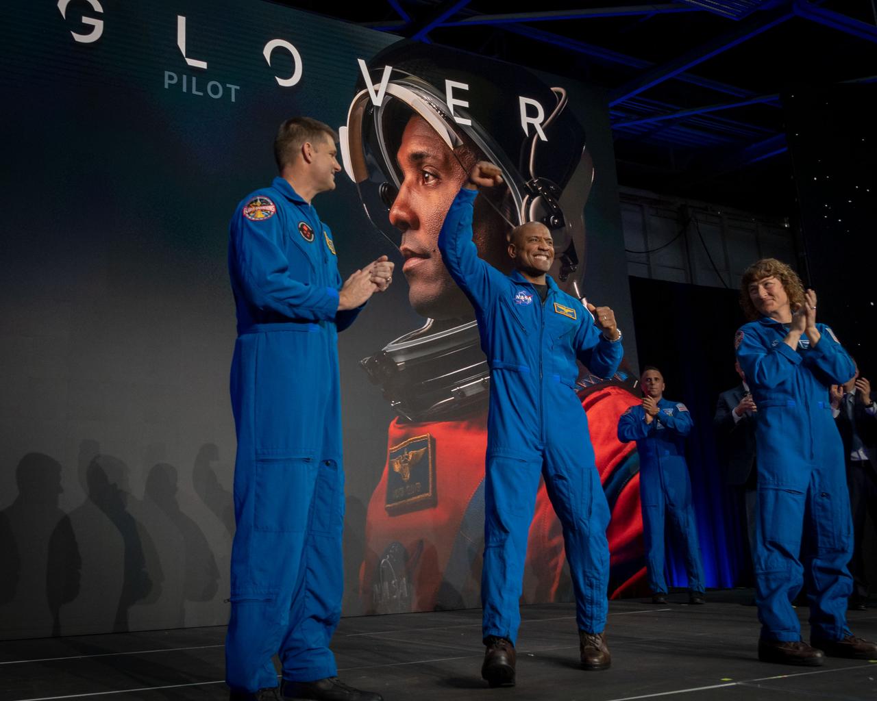 jsc2023e017432 (April 3, 2023) -- NASA astronaut Victor Glover is announced as one of four members of the Artemis II crew during a Monday, April 3, 2023, news conference at Ellington Field near NASA’s Johnson Space Center in Houston, joined by Artemis II crew members from left, CSA (Canadian Space Agency) astronaut Mission Specialist Jeremy Hansen, and NASA astronaut Mission Specialist Christina Koch. The crew is comprised of Commander Reid Wiseman, Pilot Victor Glover, and Mission Specialists Christina Koch and Jeremy Hansen. The four astronauts will venture around the Moon on Artemis II, the first crewed mission on NASA’s path to establishing a long-term presence at the Moon for science and exploration through Artemis.