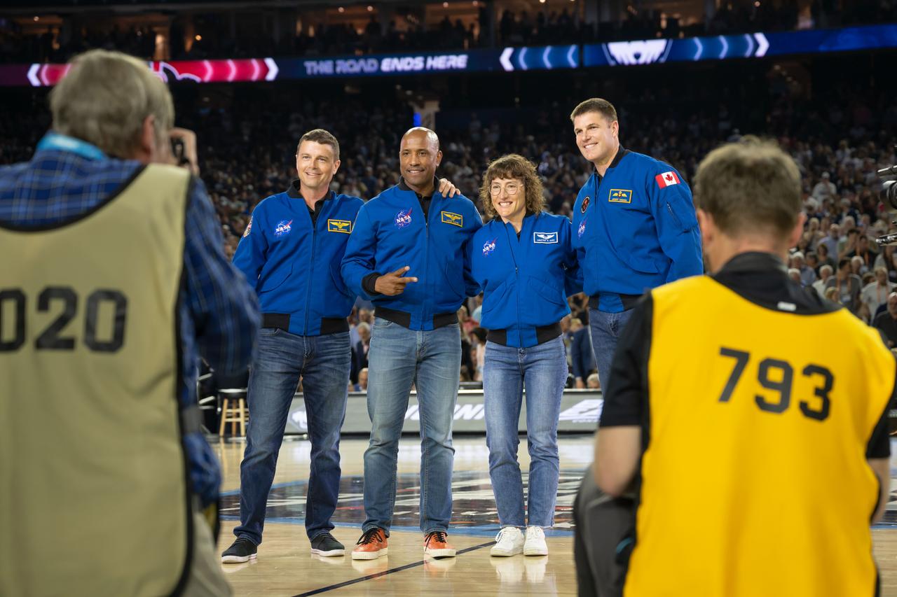jsc2023e018318 (April 3, 2023) – The Artemis II crew is introduced on the basketball court while attending the NCAA Men’s Final Four national championship game at NRG Stadium in Houston. The crew is comprised of Commander Reid Wiseman, Pilot Victor Glover, and Mission Specialists Christina Koch and Jeremy Hansen. The four astronauts will venture around the Moon on Artemis II, the first crewed mission on NASA’s path to establishing a long-term presence at the Moon for science and exploration through Artemis. From left: NASA astronauts Artemis II Commander Reid Wiseman, Pilot Victor Glover, Mission Specialist Christina Koch, and CSA (Canadian Space Agency) astronaut Mission Specialist Jeremy Hansen.