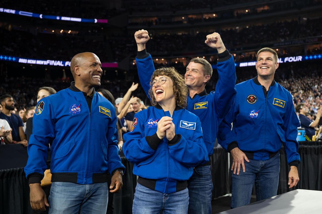 jsc2023e018325 (April 3, 2023) – The Artemis II crew cheers with the crowd while attending the NCAA Men’s Final Four national championship game at NRG Stadium in Houston. The crew is comprised of Commander Reid Wiseman, Pilot Victor Glover, and Mission Specialists Christina Koch and Jeremy Hansen. The four astronauts will venture around the Moon on Artemis II, the first crewed mission on NASA’s path to establishing a long-term presence at the Moon for science and exploration through Artemis. From left: NASA astronauts Artemis II Pilot Victor Glover, Mission Specialist Christina Koch, and Commander Reid Wiseman, and CSA (Canadian Space Agency) astronaut Mission Specialist Jeremy Hansen.