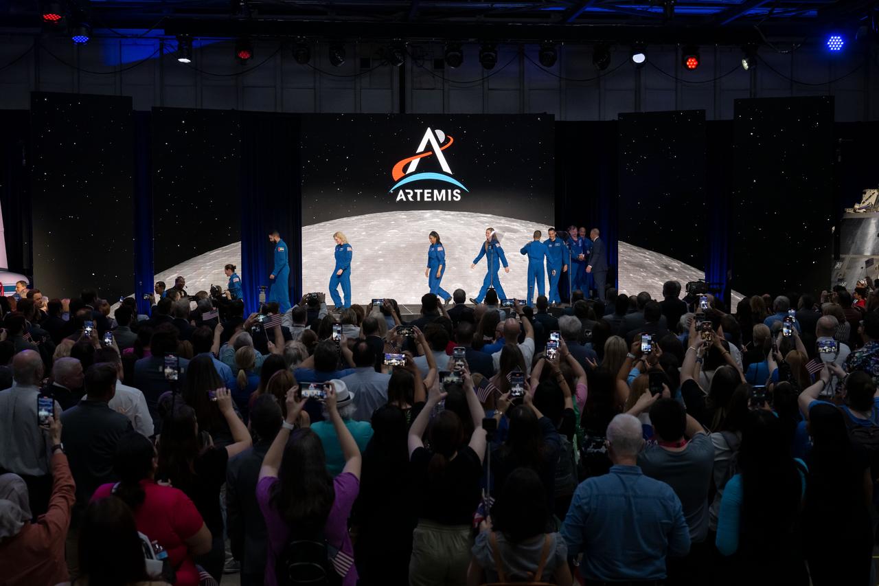 jsc2023e018436 (April 3, 2023) – NASA’s international astronaut corps greets NASA Chief Astronaut Joe Acaba and NASA Flight Operations Director Norm Knight on stage during the Monday, April 3, 2023, Artemis II crew announcement news conference at Ellington Field near NASA’s Johnson Space Center in Houston. The crew is comprised of Commander Reid Wiseman, Pilot Victor Glover, and Mission Specialists Christina Koch and Jeremy Hansen. The four astronauts will venture around the Moon on Artemis II, the first crewed mission on NASA’s path to establishing a long-term presence at the Moon for science and exploration through Artemis.