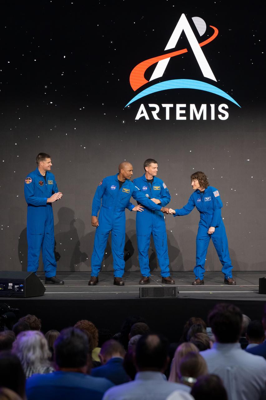 jsc2023e018452 (April 3, 2023) -- The Artemis II crew is seen on stage after being announced during a Monday, April 3, 2023, news conference at Ellington Field near NASA’s Johnson Space Center in Houston. From left: CSA (Canadian Space Agency) astronaut Mission Specialist Jeremy Hansen, and NASA astronauts Pilot Victor Glover, Commander Reid Wiseman, and Mission Specialist Christina Koch. The four astronauts will venture around the Moon on Artemis II, the first crewed mission on NASA’s path to establishing a long-term presence at the Moon for science and exploration through Artemis.