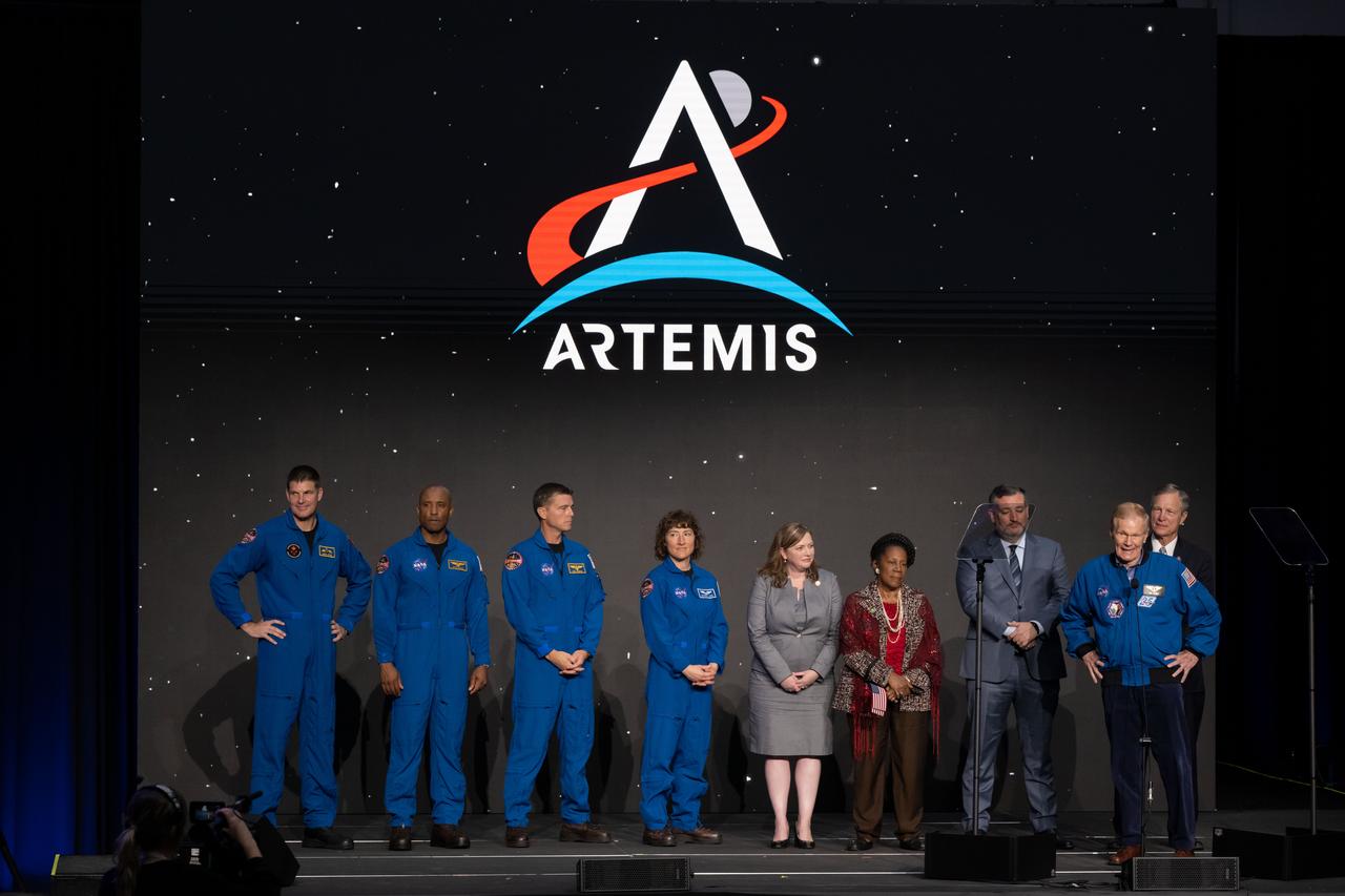 jsc2023e018469 (April 3, 2023) -- The Artemis II crew is seen on stage with the elected officials from the state of Texas and NASA leadership after being announced during a Monday, April 3, 2023, news conference at Ellington Field near NASA’s Johnson Space Center. The crew is comprised of Commander Reid Wiseman, Pilot Victor Glover, and Mission Specialists Christina Koch and Jeremy Hansen. The four astronauts will venture around the Moon on Artemis II, the first crewed mission on NASA’s path to establishing a long-term presence at the Moon for science and exploration through Artemis. From left, CSA (Canadian Space Agency) astronaut Mission Specialist Jeremy Hansen, NASA astronauts Pilot Victor Glover, Commander Reid Wiseman, and Mission Specialist Christina Koch, U.S. Representative Lizzie Fletcher, U.S. Representative Sheila Jackson Lee, U.S. Senator Ted Cruz, NASA Administrator Bill Nelson, and U.S. Representative Brian Babin.