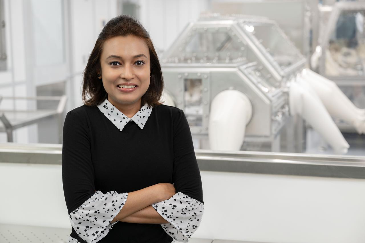 Portrait of Jannatul Ferdous, OSIRIS-REx astromaterials processor from the Astromaterials Research and Exploration Science (ARES) division at NASA's Johnson Space Center in Houston. Ferdous is seen in front of the OSIRIS-REx cleanroom at Johnson. Credit: NASA/James Blair 