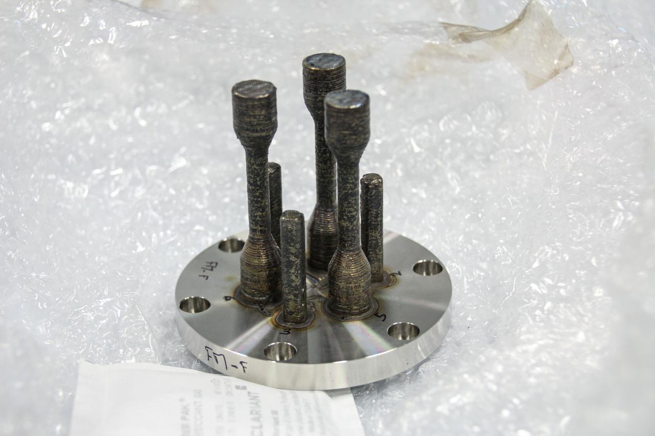 jsc2024e005970 (3/21/2023) --- A preflight image for Metal 3D printer shows one of the specimens after printing on the ground. The specimen was made from stainless steel at the ESA (European Space Agency) materials laboratory. Metal 3D printer evaluates in-space additive manufacturing for potential use in maintenance and long-duration missions to the Moon or Mars. Image courtesy of ESA/Airbus.