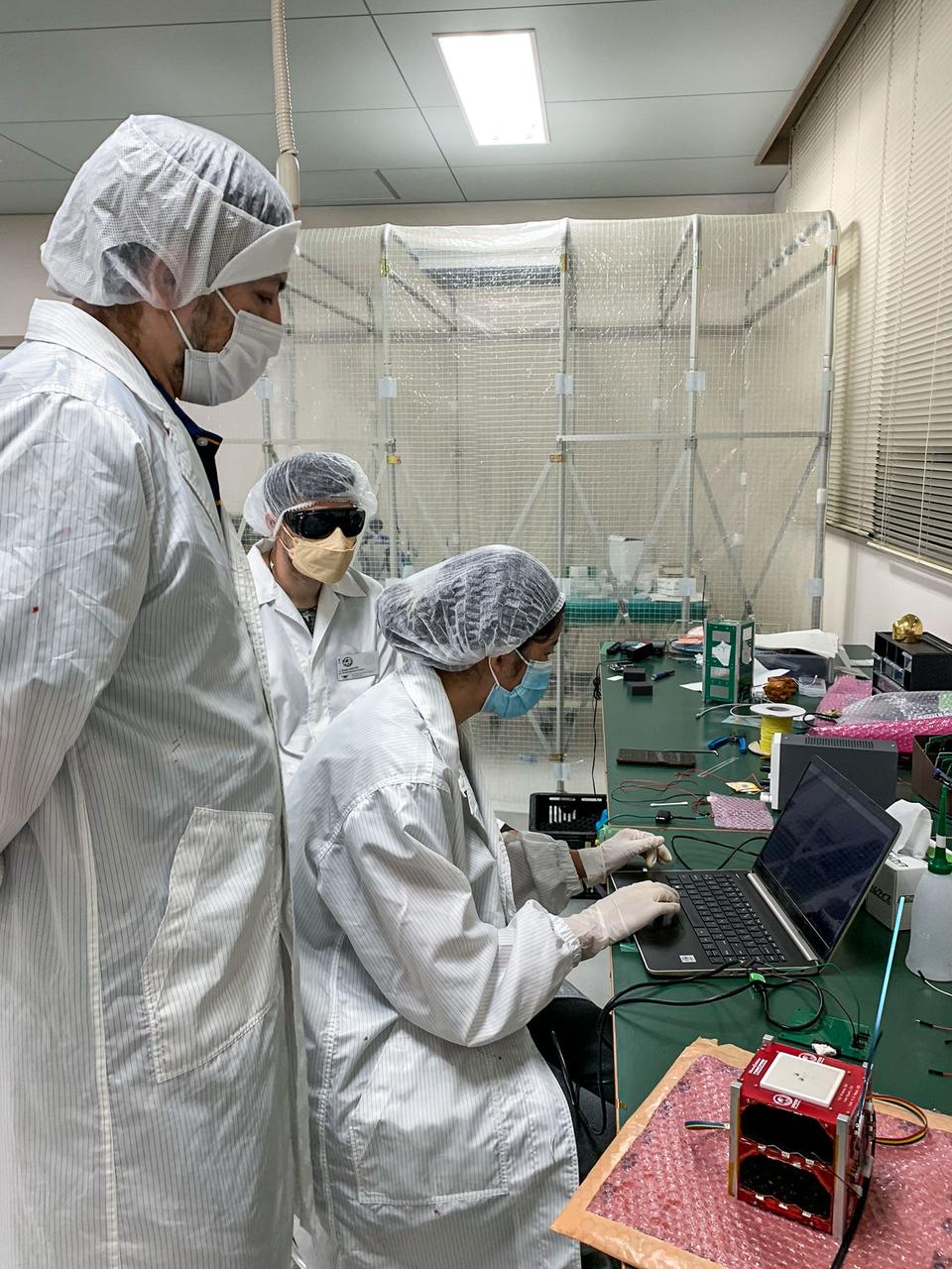 jsc2024e006086 (9/9/2024) --- Some MicroOrbiter-1 team members were analyzing the results from exposing the satellite solar panels to the sun simulator to confirm their generation of power.From left to right : SHRESTHA Hari Ram, MATTEI Giulio, ZANGMO Pema...Image Credit: MOUMNI Fahd.