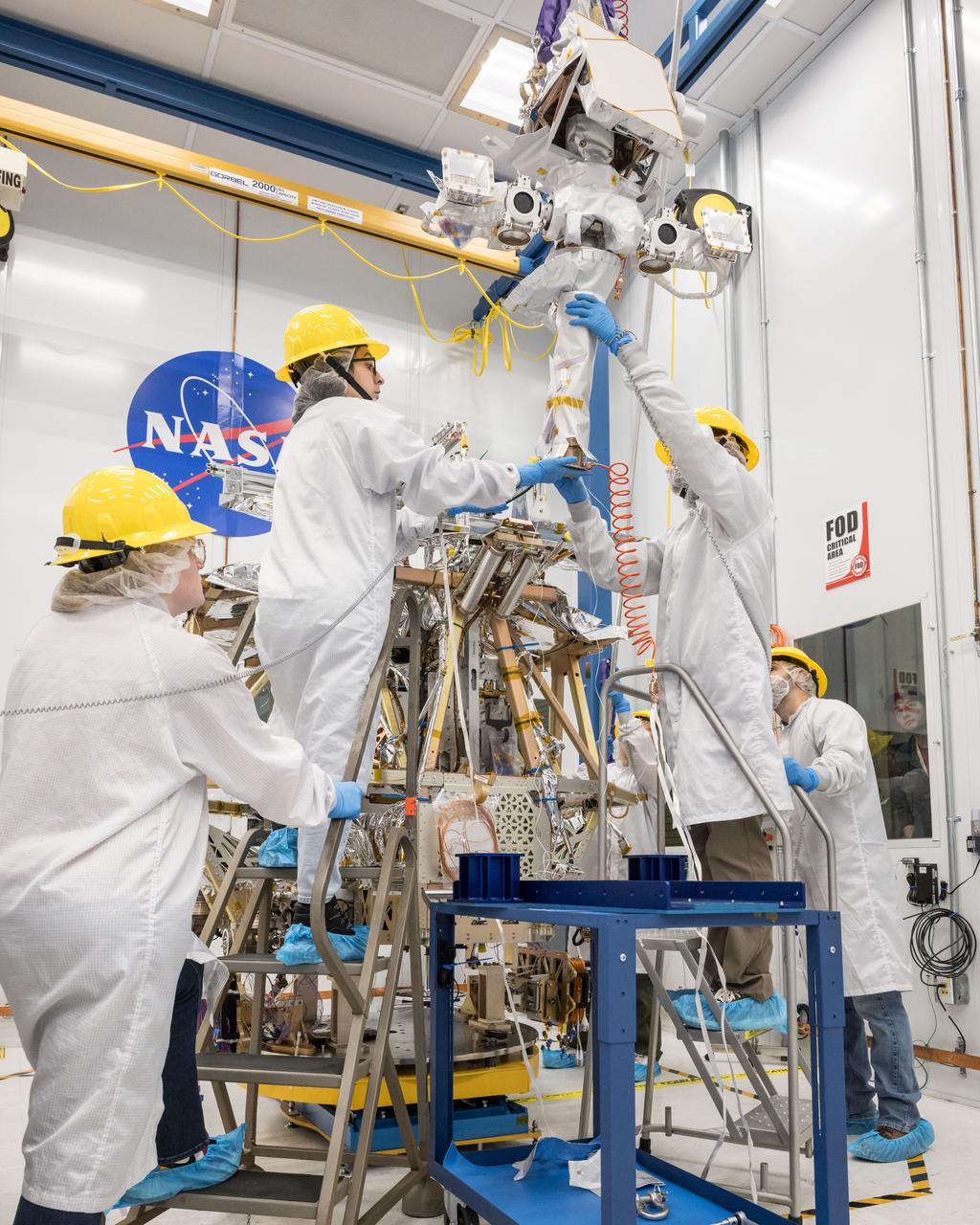 A team of engineers lifts the mast into place atop of NASA’s VIPER robotic Moon rover in a clean room at NASA’s Johnson Space Center in Houston. Credit: NASA/Helen Arase Vargas