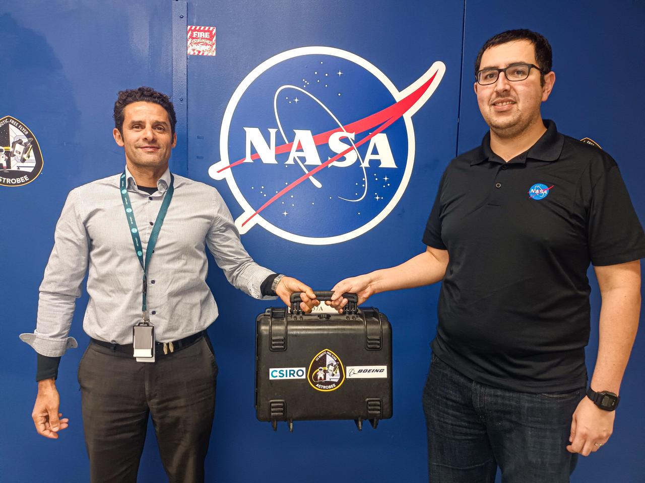 jsc2024e016242 (11/17/2023) --- CSIRO Project Lead Dr. Marc Elmouttie hands over the flight-ready Multi-Resolution Scanning payload to Jose Cortez from NASA’s Ames Research Center ahead of its final testing. The Multi-Resolution Scanning payload will be mated to the Astrobee free-flying robot, which will undertake a small flight and use the multi-resolution scanner (MRS) to create 3D maps of the interior of the International Space Station. Image courtesy of CSIRO.