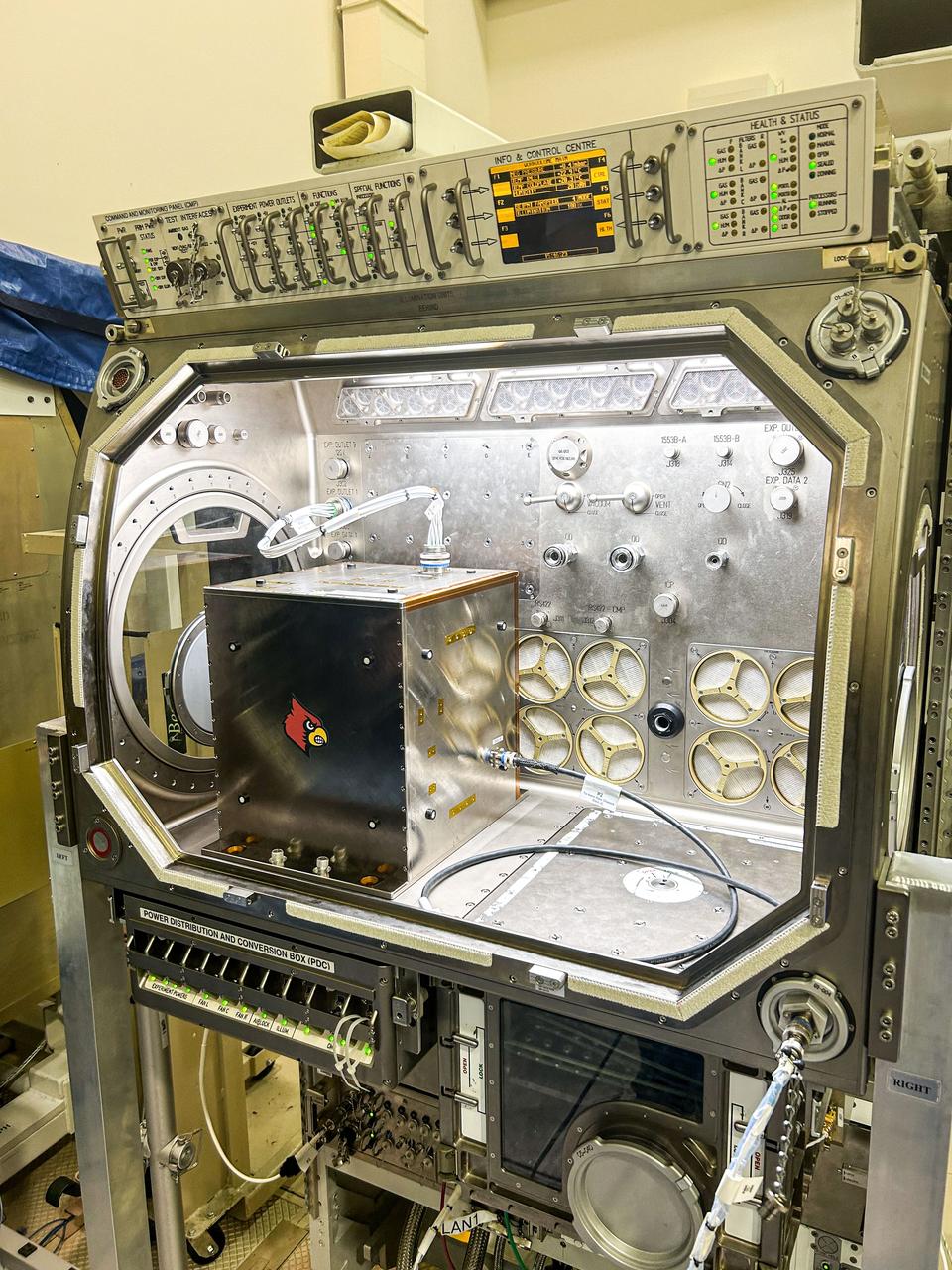 jsc2024e016253 (1/8/2024) --- The Nano Particle Haloing Suspension payload undergoes a fitting test at NASA's Marshall Space Flight Center in the Microgravity Science Glovebox replica. This payload tests controlled assembly of nanoparticles in a solution of zirconia and titanium-dioxide coated silica. Effective demonstration could lead to applications in an enhanced solar cell generation technology known as quantum-dot solar synthesis. Image courtesy of the University of Louisville.