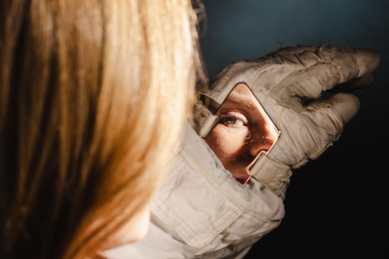 jsc2024e022262_alt NASA astronaut Zena Cardman inspects her suit’s wrist mirror at the NASA Johnson Space Center photo studio on March 22, 2024.  Photographer: Josh Valcarcel – Johnson Space Center
