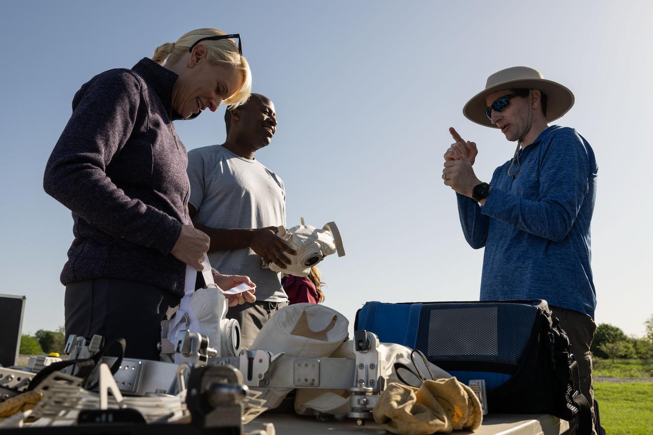 Paul Reichert, astronaut technical imaging instructor, shows NASA astronauts Kate Rubins and Andre Douglas how to use the Handheld Universal Lunar Camera before a simulated moonwalk at NASA’s Johnson Space Center on March 26, 2024. Credits: NASA / Josh Valcarcel