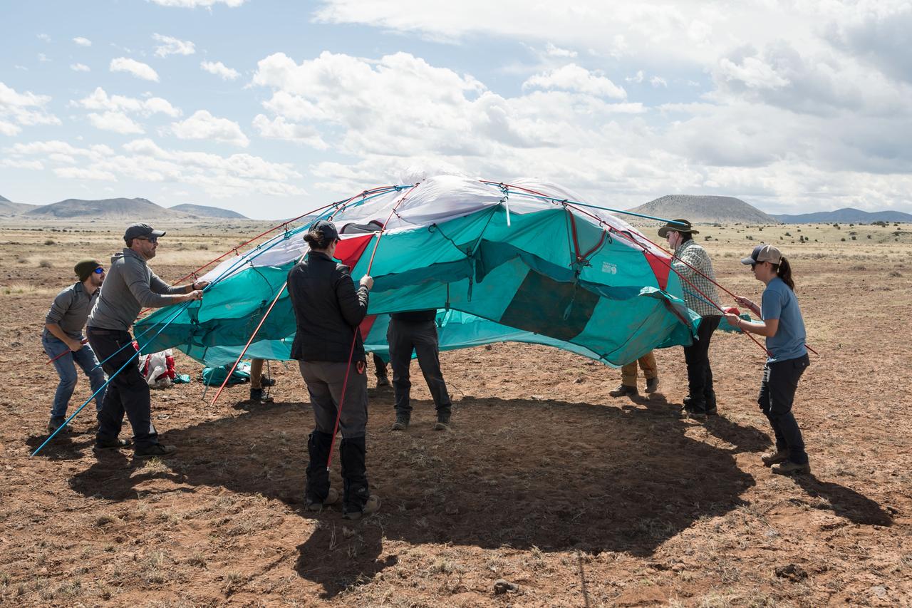 NASA teams work to set up a one of many tents that will serve as the base camp for the Joint Extravehicular Activity and Human Surface Mobility Test Team Field Test 5 (JETT5) in the San Francisco Volcanic Field in Northern Arizona on May 11, 2024.  Credit: NASA/Josh Valcarcel 