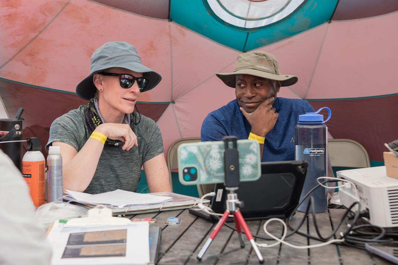 NASA astronauts Kate Rubins and Andre Douglas review test objectives and traverse plans before their first simulated moonwalk in a week-long field test consisting of four simulated moonwalks and six advanced technology runs in the San Francisco Volcanic Field in Northern Arizona on May 13, 2024  Credit: NASA/Josh Valcarcel 