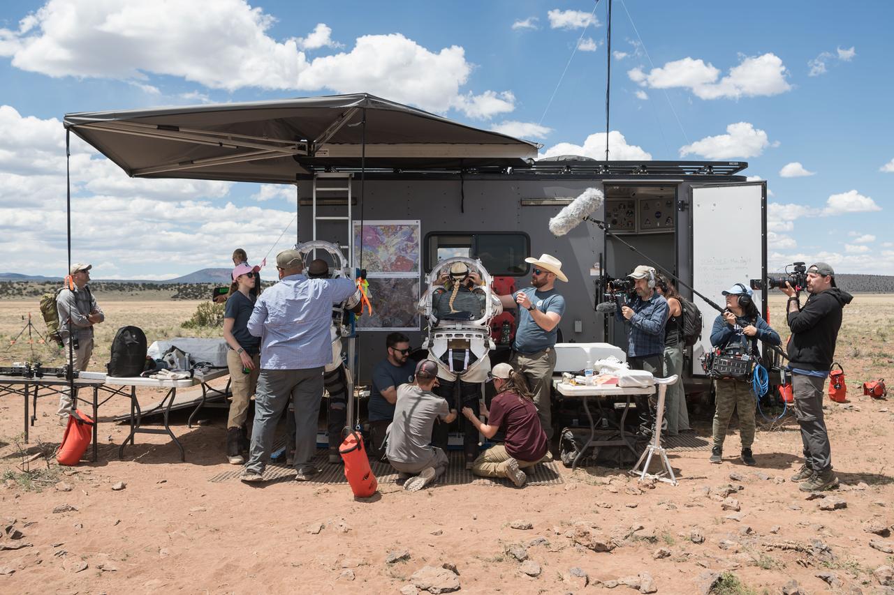 NASA engineering teams help NASA astronauts Andre Douglas (left) and Kate Rubins (right) get into their unpressurized mockup spacesuits before they perform the first of four simulated moonwalks north of Flagstaff, Arizona on May 13, 2024.    Credit: NASA/Josh Valcarcel 