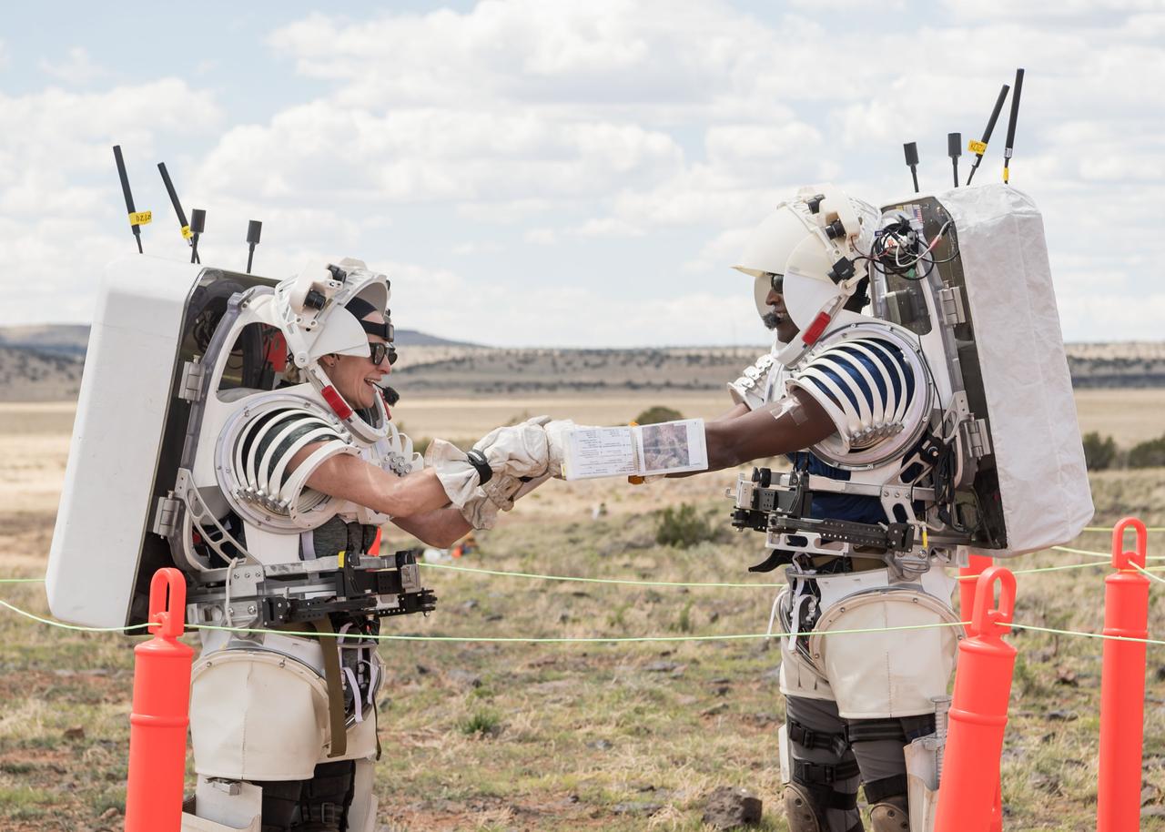 NASA astronauts Kate Rubins and Andre Douglas congratulate each other after the completion of the first simulated moonwalk in a week-long field test consisting of four simulated moonwalks and six advanced technology runs in the San Francisco Volcanic Field in Northern Arizona on May 13, 2024.   Credit: NASA/Josh Valcarcel 