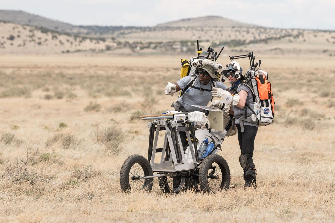 NASA astronauts Andre Douglas and Kate look ahead at their traverse during a simulated moonwalk in the San Francisco Volcanic Field in Northern Arizona on May 14, 2024.  Credit: NASA/Josh Valcarcel 