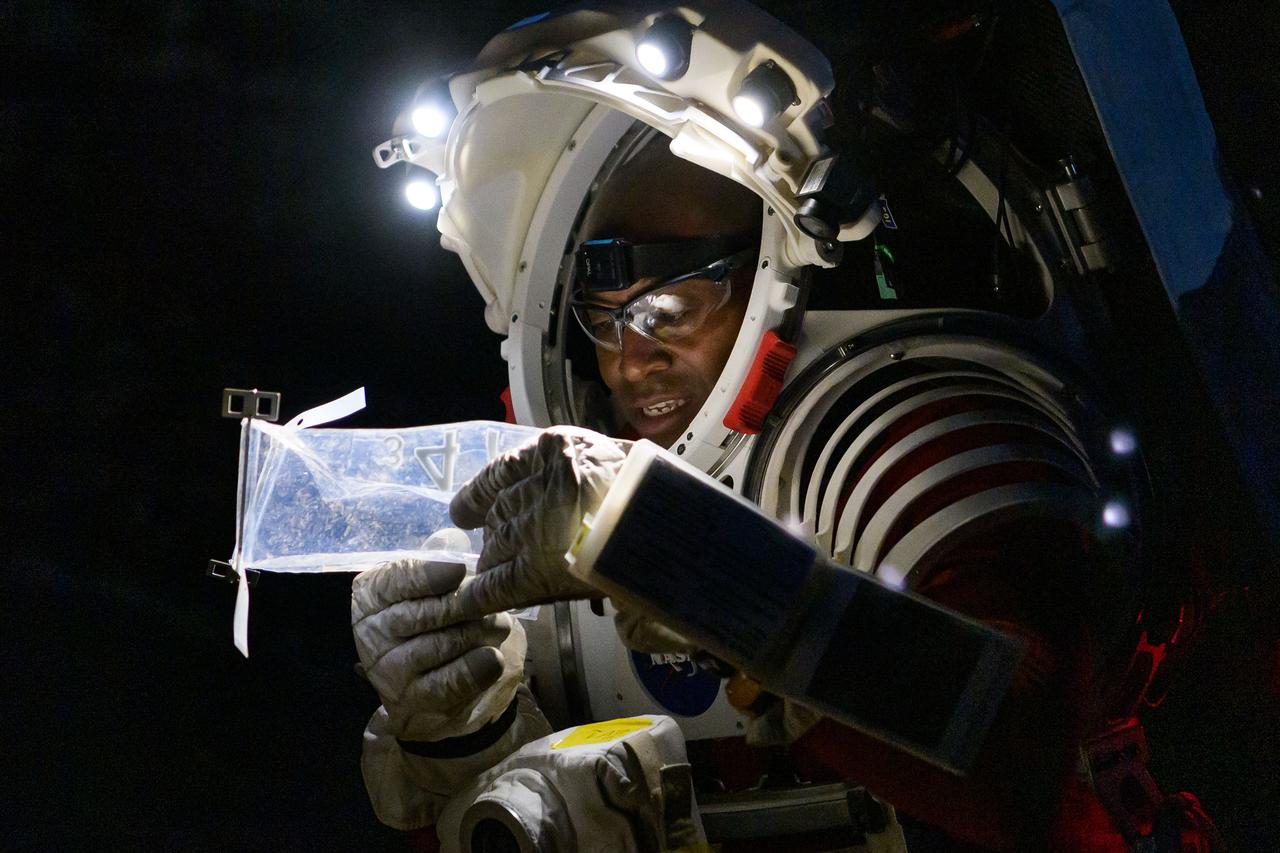 NASA astronaut Andre Douglas examines a geologic sample collected during a nighttime simulated moonwalk in the San Francisco Volcanic Field in Northern Arizona on May 16, 2024.  Credit: NASA/Josh Valcarcel 