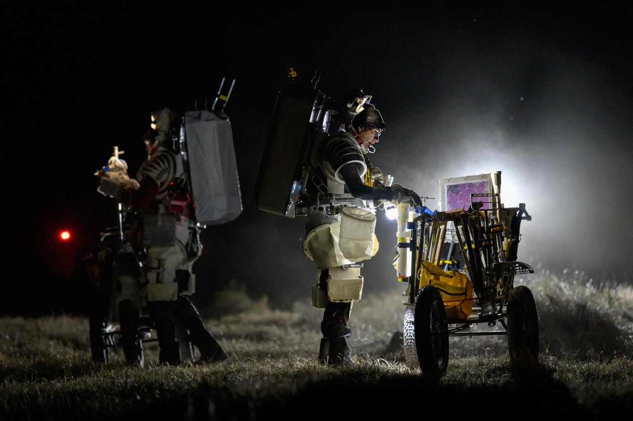 NASA astronaut Kate Rubins conducts a tool audit to ensure she has all of her tools while NASA astronaut Andre Douglas reviews procedures during a nighttime simulated moonwalk in the San Francisco Volcanic Field in Northern Arizona on May 16, 2024.  Credit: NASA/Josh Valcarcel 